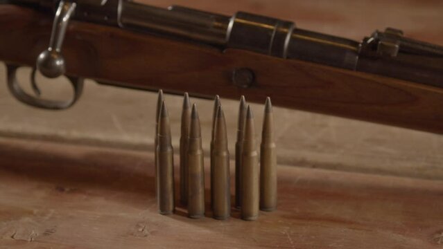 Close Dolly of 8mm cartridges in front of WW2 era Mauser K98