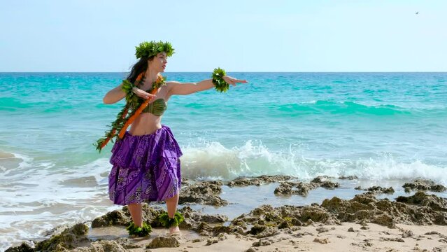 Beautiful hawaiian woman performing hawaiian dance happily barefoot on the beach