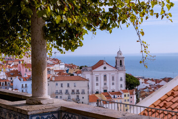 Beautiful aerial view of St. Stephen's Church in Lisbon, Portugal against a blue sky and seaside