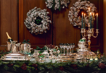 Fototapeta na wymiar Christmas table with Silver plate against decorated wooden wall