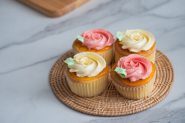 Obraz na płótnie Canvas Homemade Cupcake Topped with Vanilla and Strawberry Cream