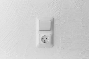 Socket and light off turn on button on the background of the switch white wall of the house, close up