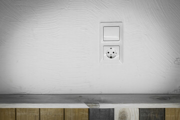 Socket and light off turn on button on the background of the switch white wall of the house, close up