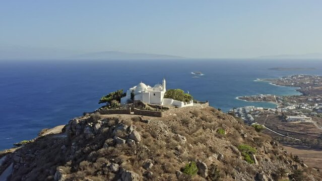 Paros Greece Aerial v7 drone fly around hilltop st antonios monastery with beautiful white church facade overlooking at breathtaking landscape and aegean seascape - September 2021