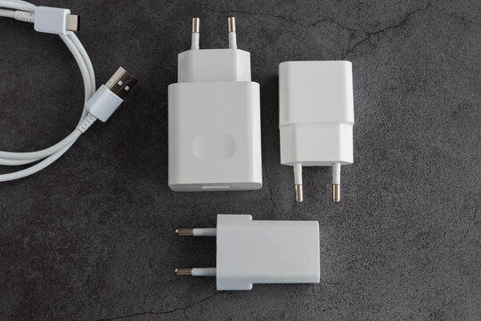 Three phone or tablet chargers on dark background