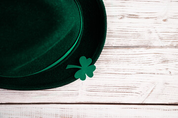 Leprechaun hat and shamrock clover leaves on white background. Happy St. Patrick's Day.