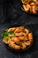 Grilled shrimp with garlic and parsley. Spiked shrimp-bear on a plate . Bering shrimp. Menu concept for restaurants. Dark photo.
