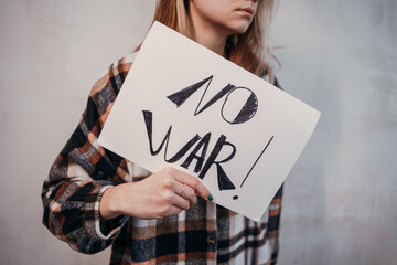 Young woman holding a placard protesting No to war