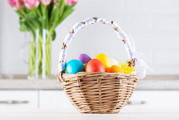 Easter colored eggs in a basket on the kitchen table.