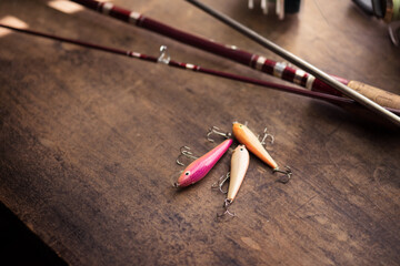 Preparing for lure fishing. Fishing rod and lure on an old wooden desk.
