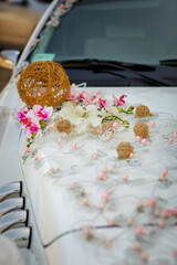 The wedding car of the newlyweds is beautifully decorated with flowers. Wedding