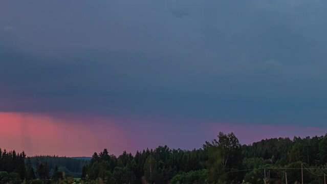 Heavy tunderstorm clouds over green forest with lightning bolt striking again and again at distance while passing by in timelapse.