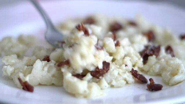 Halu&scaron;ky - traditional slovak food on plate and eating with fork in 4k UHD video - Bryndzove halusky, traditional national slovak food. Potato dumplings with bacon and bryndza sheep cheese