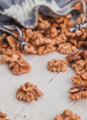 Many walnut kernels in eco bag on a wooden background. Healthy eating concept.