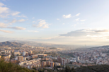 Panorama of Barcelona from the air in the early morning. City with shadows from the clouds. Dramatic sky over the city. Autumn in Barcelona, Spain.