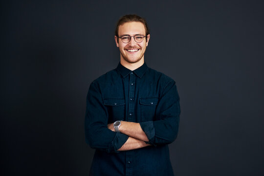 Be prepared to stand out in business. Cropped portrait of a handsome young businessman standing alone with his arms folded against a black background in the studio.