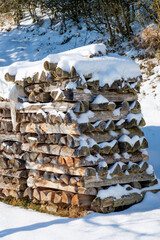 Aufgestapeltes Holz / Holzwirtschaft: Schneebedecktes Brennholz / Meterholz (Holzlager im Winter bei Schnee)