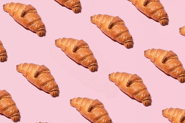 Traditional French pastry, croissants pattern against pastel pink background. The ultimate Parisian breakfast. 