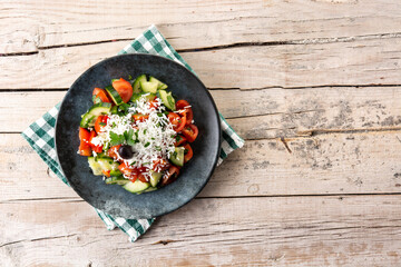 Traditional Bulgarian shopska salad with tomato,cucumber and bulgarian sirene cheese on wooden table