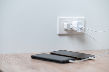 smart phone charger plugged on wooden with plugged at home.