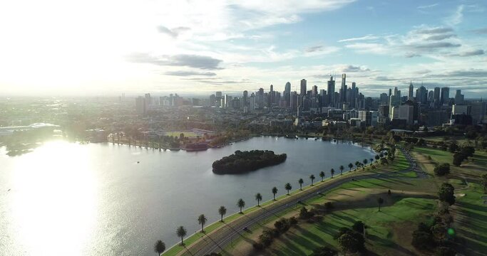 Smooth pan and decent over the Albert Park Lake showing Melbourne CBD under glorious bright light.
