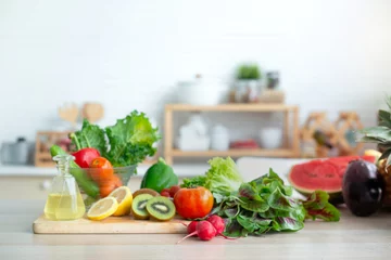 Tuinposter Fresh fruits and vegetables on wooden table in bright white kitchen, healthy lifestyle concept © chomplearn_2001
