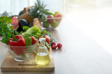 Fresh fruits and vegetables in glass bowl on wooden tray in kitchen, with copy space, healthy lifestyle concept