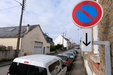Voitures garées dans une rue de Vannes en Bretagne avec un panneau de signalisation routière...