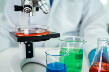 Asian scientist biochemist or microbiologist working research with a microscope in laboratory. For protect outbreak Coronavirus Covid19, bacteria and germs.
