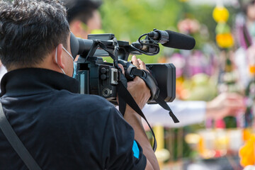 Video camera operator working with his equipment. video cinema production. Covering an event with a...