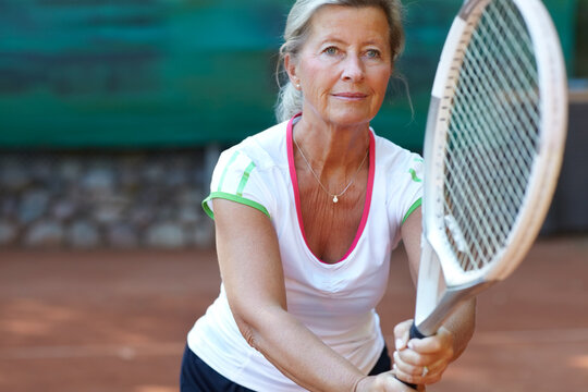 Dedicated tennis player. Senior woman preparing to return a serve during a game of tennis.