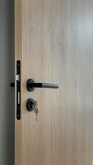 Obraz premium Closeup detail of door handle in house, wooden door with black handle set.