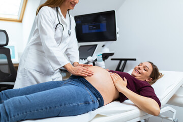 Happy expectant mother doing ultrasound scan in the prenatal clinic. Gynecology examination and consultation.