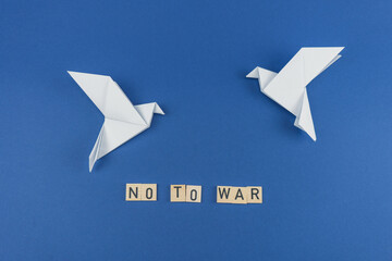 Białe gołębie symbolizujące pokój na niebieskim tle i napis nie dla wojny.