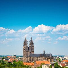 Fototapeta premium Cover page with Magdeburg historical downtown, Elbe river, city park and the ancient medieval cathedral in Spring colors at blue cloudy sky and sunny day, Magdeburg, Germany.