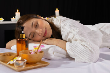 Obraz na płótnie Canvas An Asian girl sleep with smile and relaxing in spa salon