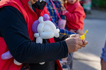 man making funny balloon unicorn figure for children
