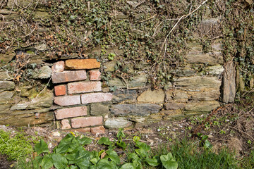 Red bricks in a Cornish stone wall Lerryn Cornwall