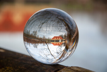 Haus und Wasser spiegelt sich in Glaskugel