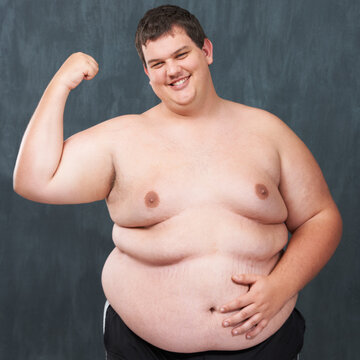 Big, strong and sexy. Studio shot of an obese young shirtless man flexing his bicep.