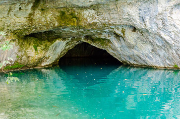 Cave on Korana river in Plitvice Lakes National Park, Croatia. Beautiful Calm Turquoise Waters. White Rocks Reflect on the Water