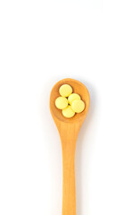 Pills on a spoon isolate on a white background. Selective focus.