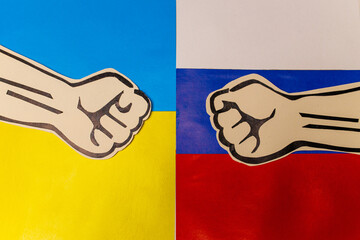 two cardboard fists on flags of Russia and Ukraine. Russian versus Ukraine trade third world war...