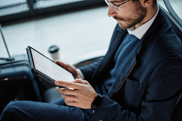 businessman works on a digital tablet while waiting for his flight . close-up.