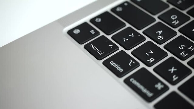 Hand pressing control key on modern laptop keyboard close-up slow motion 