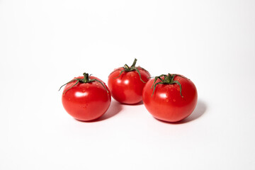 Three ripe tomatoes isolated on a white background.