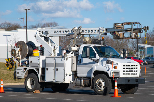 Front and side view of parked communication utility trucks in residential neighborhood