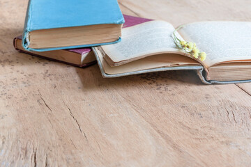 opened and some heap of old vintage hardcover books on wooden table