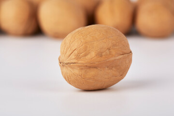 Walnuts on a white background, one nut in the foreground