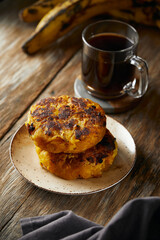  Tortilla de platano a traditional Ecuadorian appetizer served with coffee. It’s on a wooden background.